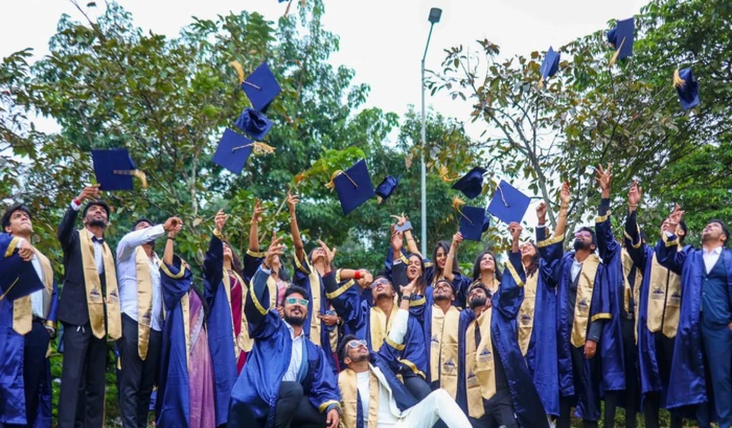 Graduates tossing their caps outside the college