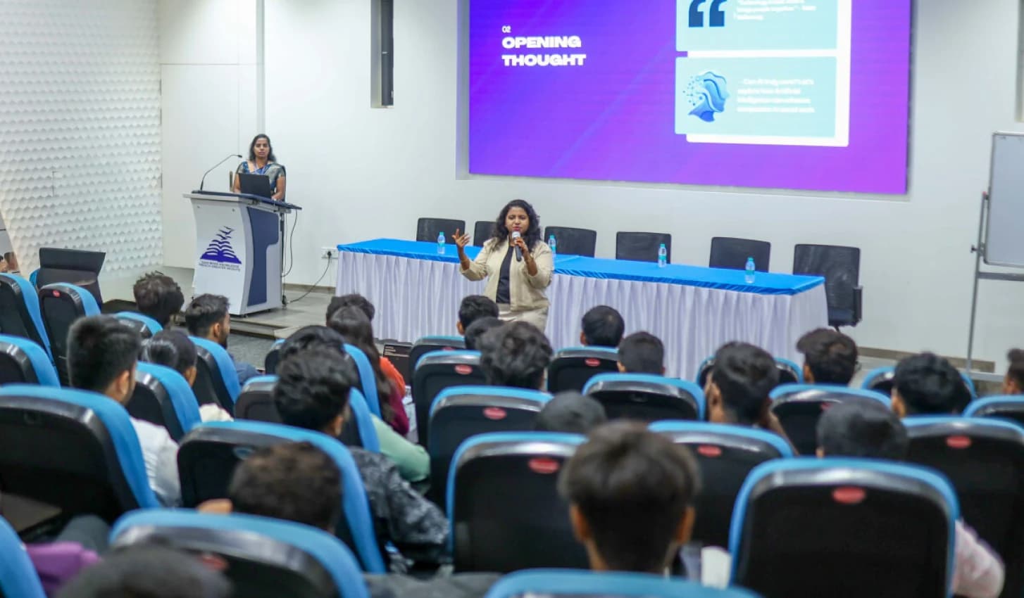 A speaker addressing students in the auditorium