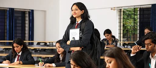 Student holding a notebook in a classroom